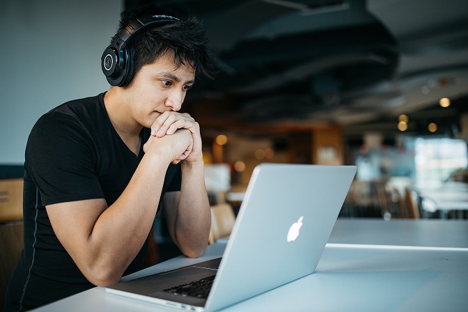 Student trying to recover with headphones on laptop